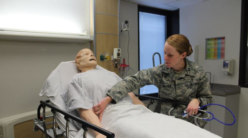 Capt. Catherine Volkmer, 88th Medical Group sustainment medical and readiness trained program manager, Wright-Patterson Air Force Base, checks the vital signs on a simulated patient. The mannequins can be programmed to exhibit various vital signs tailored to the type of training. The 88th Medical Group simulation center offers simulated training to an array of healthcare personnel such as physicians, nurses, and medical technicians to include paramedics, emergency medical technicians, and respiratory therapists. (U.S. Air Force photo/Stacey Geiger)