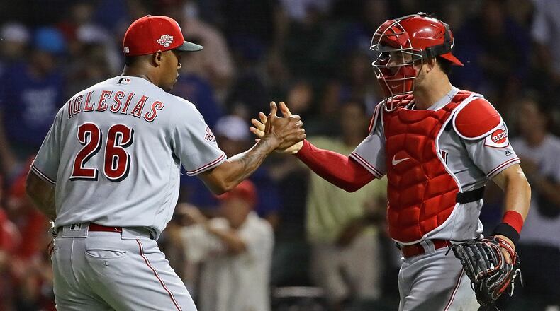 CHICAGO, ILLINOIS - JULY 15: Raisel Iglesias #26 and Kyle Farmer #52 of the Cincinnati Reds celebrate a win against the Chicago Cubs at Wrigley Field on July 15, 2019 in Chicago, Illinois. The Reds defeated the Cubs 6-3. (Photo by Jonathan Daniel/Getty Images)