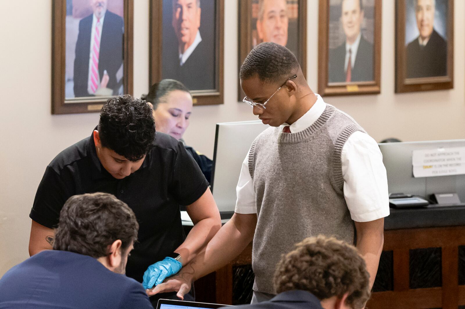 Defendant Taymor McIntyre is finger printed at the Cadena-Reeves Justice Center in San Antonio, on Monday, April 14, 2025. (Josie Norris/The San Antonio Express-News via AP)