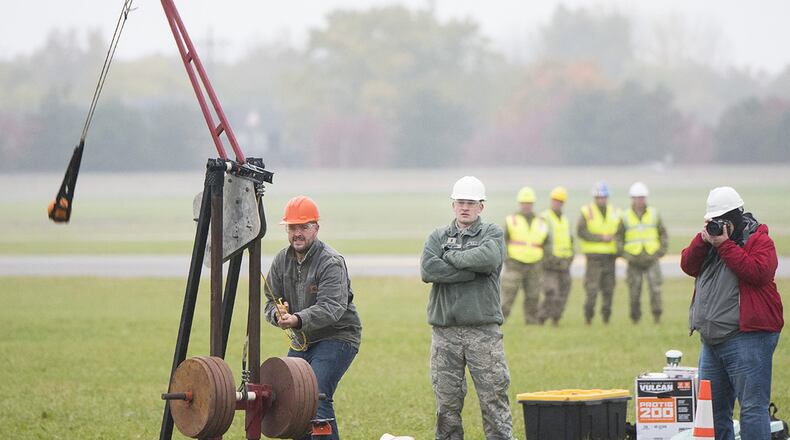 An Air Force Life Cycle Management Center’s F-15 Engineering Branch team member pulls the trigger on their trebuchet-style catapult to hurl a small pumpkin during the 14th annual Wright-Patterson Air Force Base pumpkin chuck Nov. 2. Representatives from the 88th Air Base Wing safety office watch in the background. (U.S. Air Force photo/R.J. Oriez)