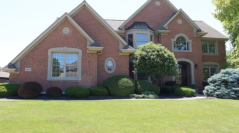 The 4-bedroom brick home has about 4,660 sq. ft. of living space, including the finished basement. A concrete driveway leads up to the oversized, 3-car garage. CONTRIBUTED PHOTO BY KATHY TYLER