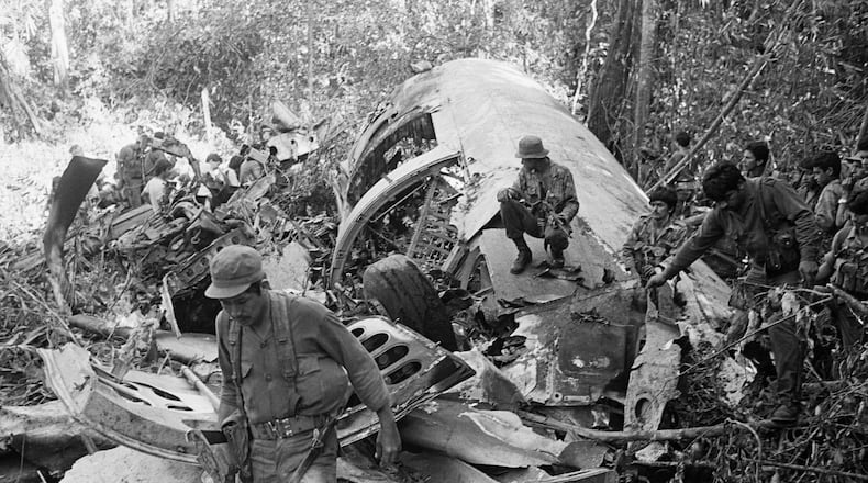 FILE - Sandinista soldiers walk amid the debris after shooting down a supply plane of the U.S.-backed rebels in Loma El Arenal, Nicaragua, on Jan. 24, 1988. (AP Photo/Mario Tapia, File)