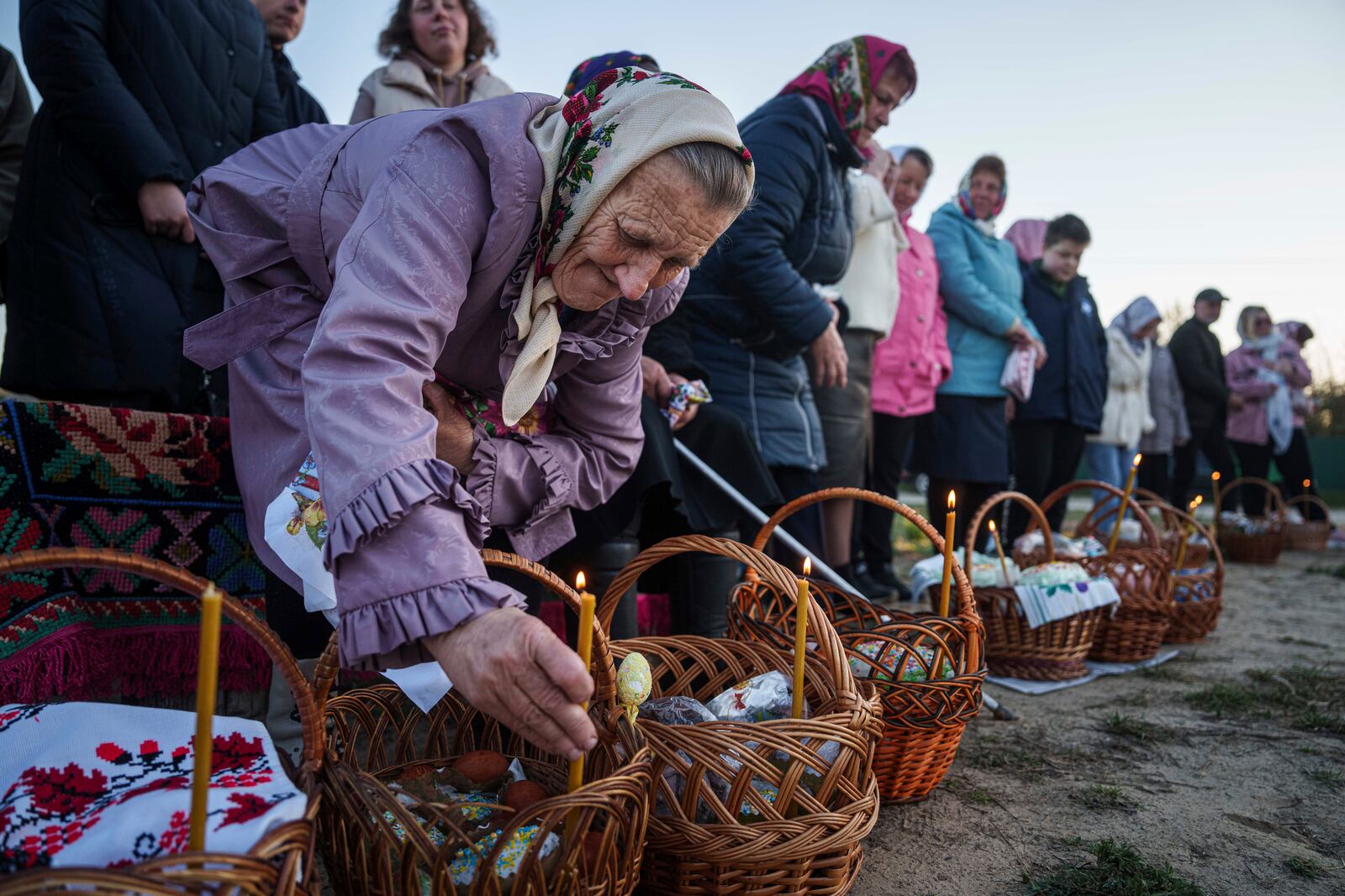 An elderly woman prepares her Easter baskets to be blessed during celebration of the Orthodox Easter in Krasne village, Ukraine, on Sunday, April 20, 2025. (AP Photo/Evgeniy Maloletka)
