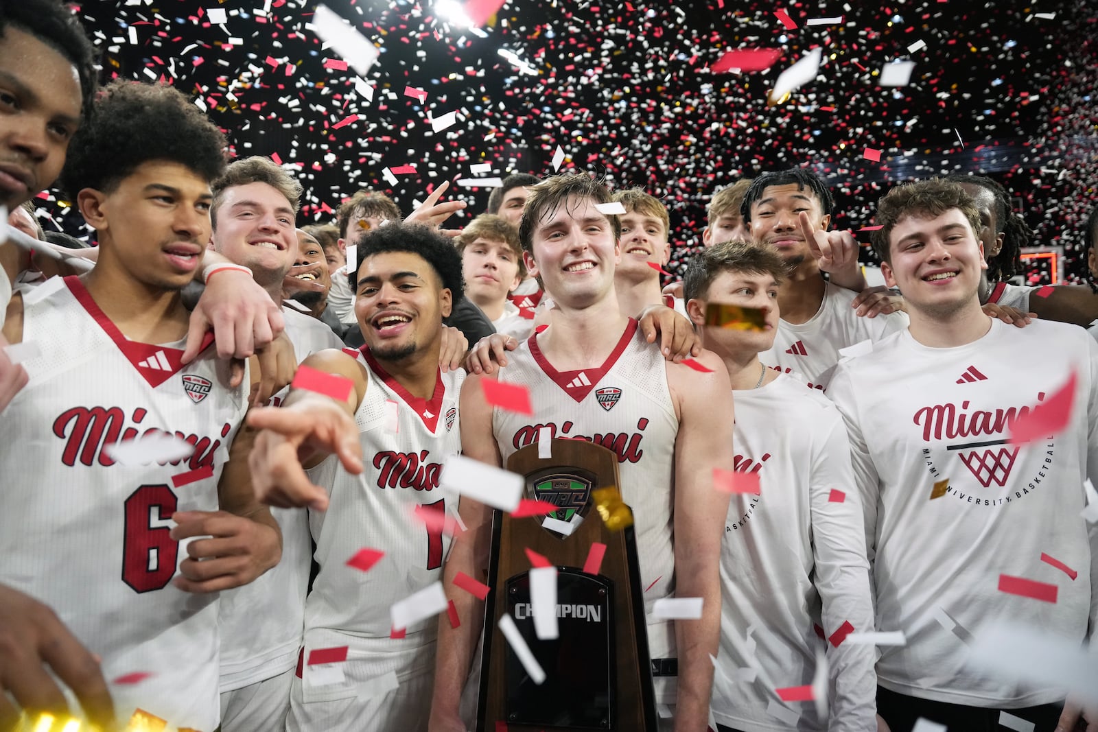 Miami (OH) guard Peter Suder, center, and the team celebrate the regular-season trophy at the conclusion of an NCAA college basketball game against Toledo, Tuesday, March 3, 2026, in Oxford, Ohio. (AP Photo/Kareem Elgazzar)