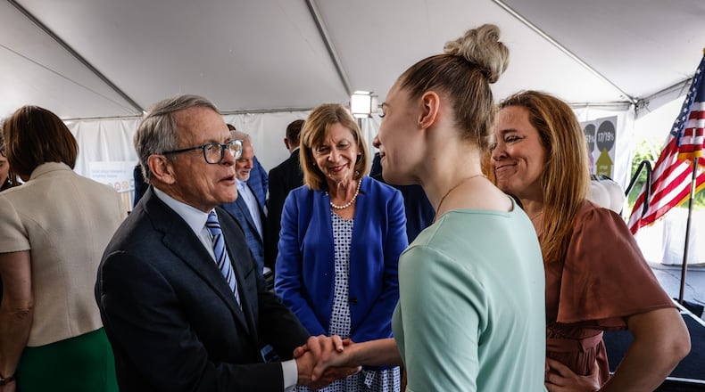 Ohio Gov. Mike DeWine, left shakes the hand of Emma Brun, from Miamisburg at a press conference at Dayton Children's Hospital. Dayton Children's Hospital will soon break ground on a $100 million building devoted to mental and behavioral health  for children. Fran DeWine is center left and Emma's mother, Sybil Brun is on the right.
JIM NOELKER/STAFF