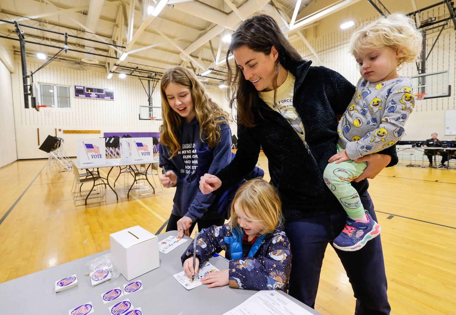 Attie Kempf-Marshall stands with Harper Marshall, 13, Brad Marshall, 2, and Lettie Marshall, 4, as they vote on the kid ballot at the polling location in the gymnasium of Creekview Elementary School Tuesday, Nov. 4, 2025 in Middletown. NICK GRAHAM/STAFF