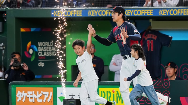 Japan's Shohei Ohtani enters the arena with young escorts before the start of a World Baseball Classic Pool C game between Japan and Taiwan Friday, March 6, 2026 in Tokyo. (AP Photo/Eugene Hoshiko)