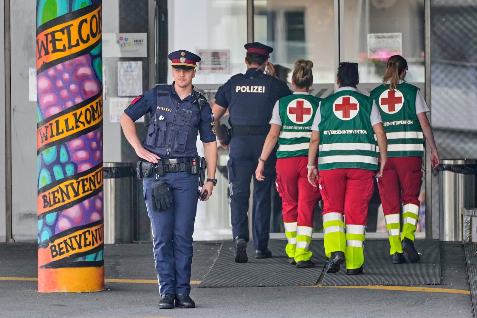 A police officer guars the entrance of a school where a former student opened fire the day before fatally wounding 10 people and injuring many others before taking his own life, Graz, Austria, Wednesday, June 11, 2025. (AP Photo/Darko Bandic)