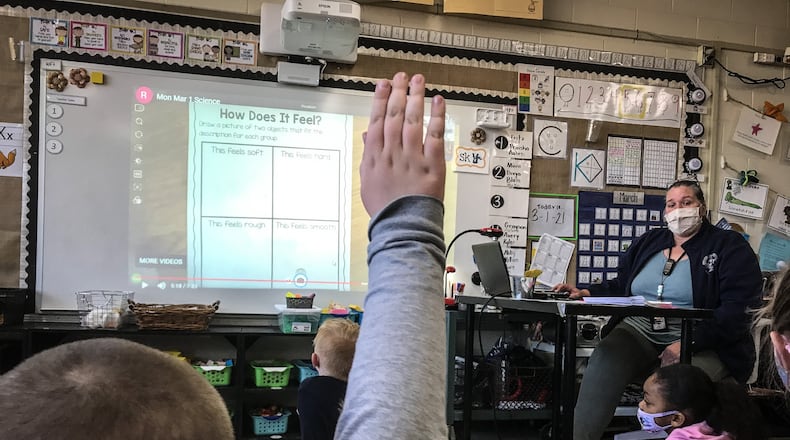Orchard Park Elementary teacher Cary Forlines answers question from first-graders Tuesday March 2, 2021. The Kettering school opened for in-person learning in late January after months of COVID-19 restrictions.
