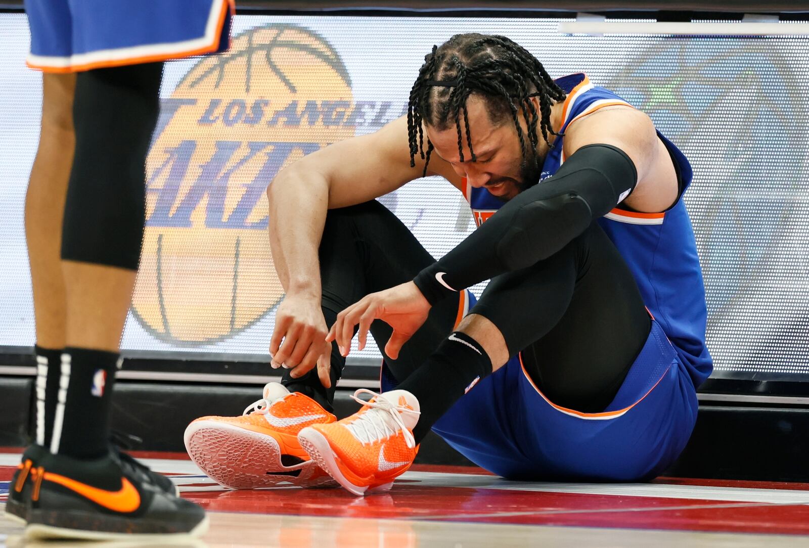 New York Knicks guard Jalen Brunson (11) sits against the scorers table after getting injured during the second half of Game 4 of an NBA basketball first-round playoff series Sunday, April 27, 2025, in Detroit. (AP Photo/Duane Burleson)