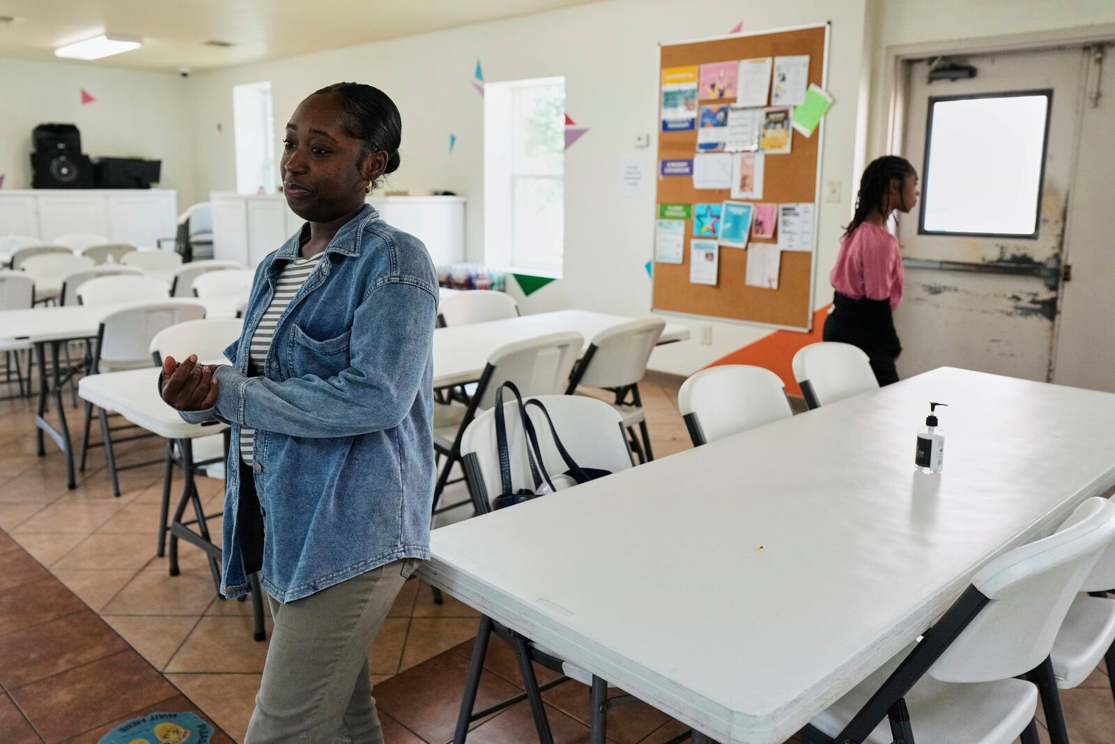 Lineicia Hollman, left, and her daughter, Hailey Robinson, 8, stand in the dining area of Mission of Yahweh women's shelter on Tuesday, April 1, 2025, in Houston. (AP Photo/Ashley Landis)