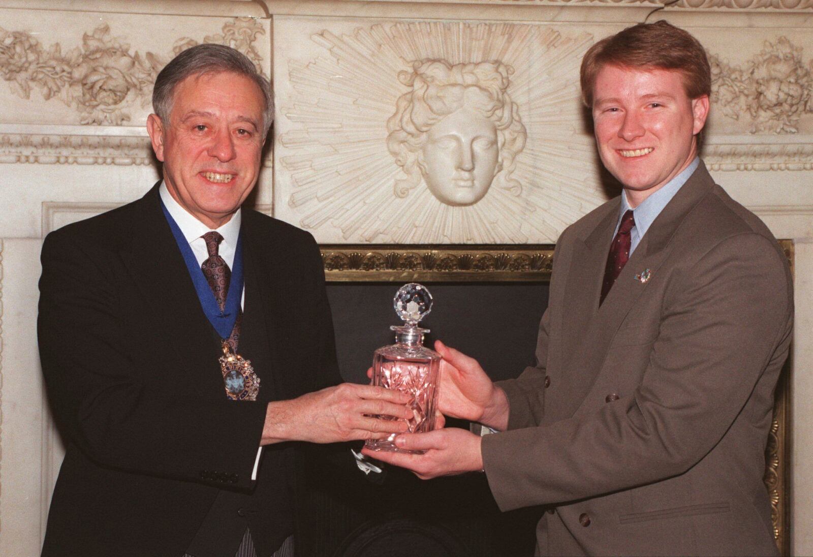 FILE - Charles "Chuck" Porter IV receives an award for his picture of a firefighter holding a baby in the aftermath of the Oklahoma bombing in London's Mansion House from the Lord Mayor of London Alderman John Chalstrey, right, on Jan. 26 1996, in London's Mansion House. (AP Photo/Dave Caulkin, File)