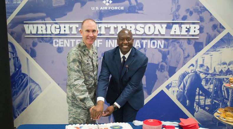 Col. Leonard T. Rose, 88th Mission Support Group commander, and Jermaine Wilson, Wright-Patterson Exchange general manager, cut a commerative cake at the Exchange’s grand re-opening ceremony Oct. 25. The event culminated a $6.4 million renovation for the nearly 40-year-old facility, which was last remodeled in 2010. (U.S. Air Force photo/John Harrington)
