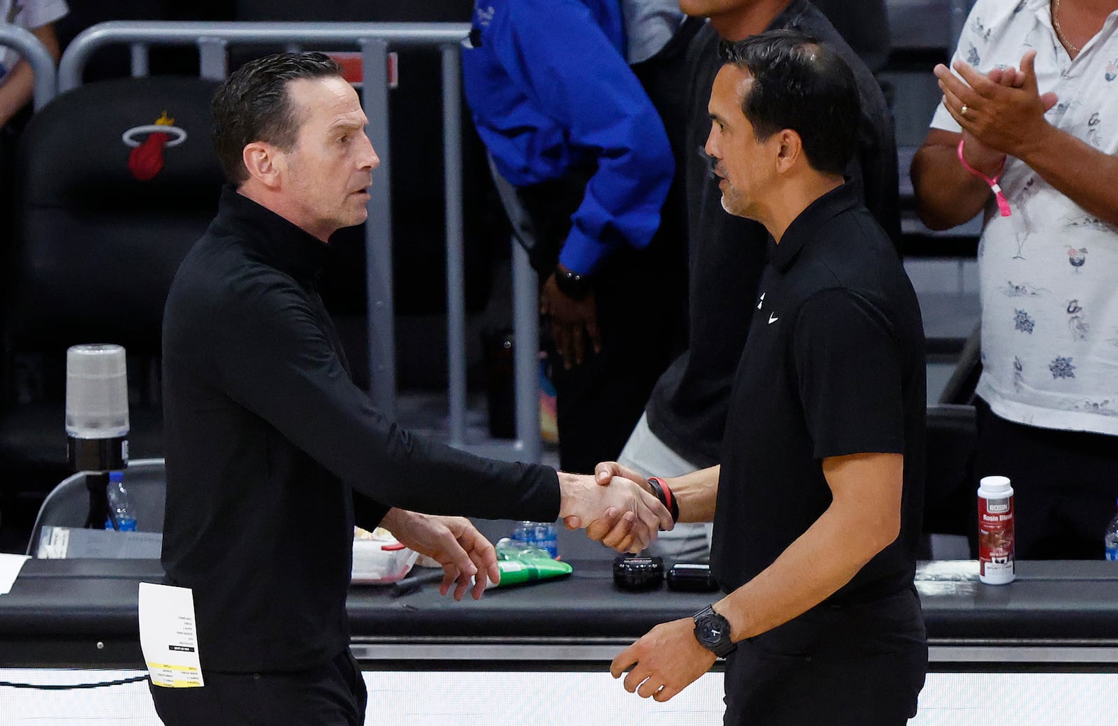 Cleveland Cavaliers head coach Kenny Atkinson, left, and Miami Heat head coach Erik Spoelstra, right, shake hands following Game 4 of an NBA basketball first-round playoff series, Monday, April 28, 2025, in Miami. (AP Photo/Rhona Wise)