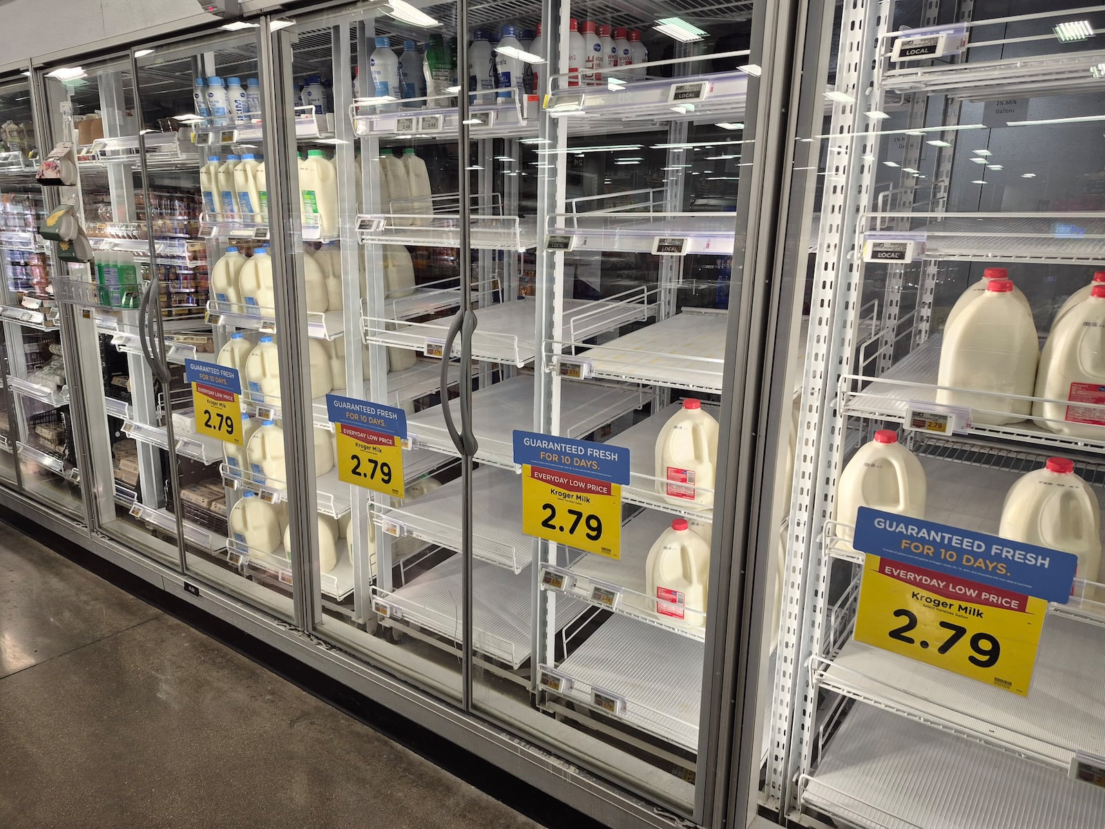 The milk shelves at the Springboro Kroger were empty Thursday and people stocked up before Saturday's forecasted large snow storm. Michael Kurtz / Staff