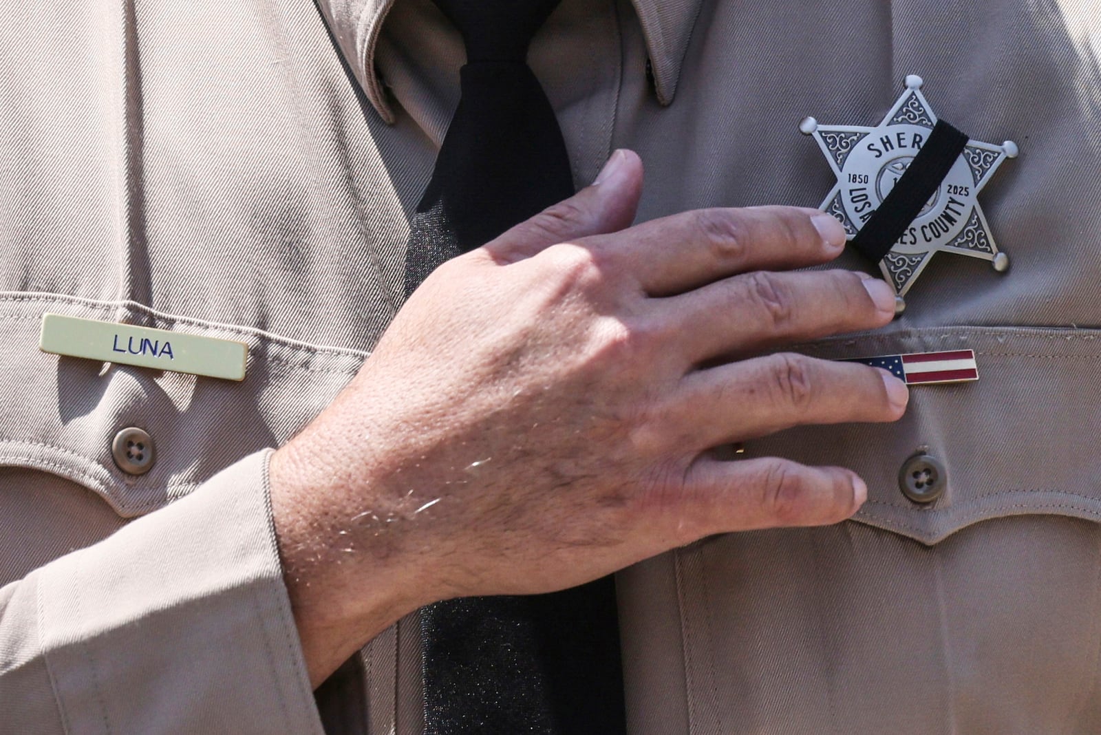 Los Angeles County Sheriff Robert Luna wears a band over his badge after three members of the department were killed in an explosion at a training facility on Friday, July 18, 2025, in Los Angeles. (AP Photo/Etienne Laurent)