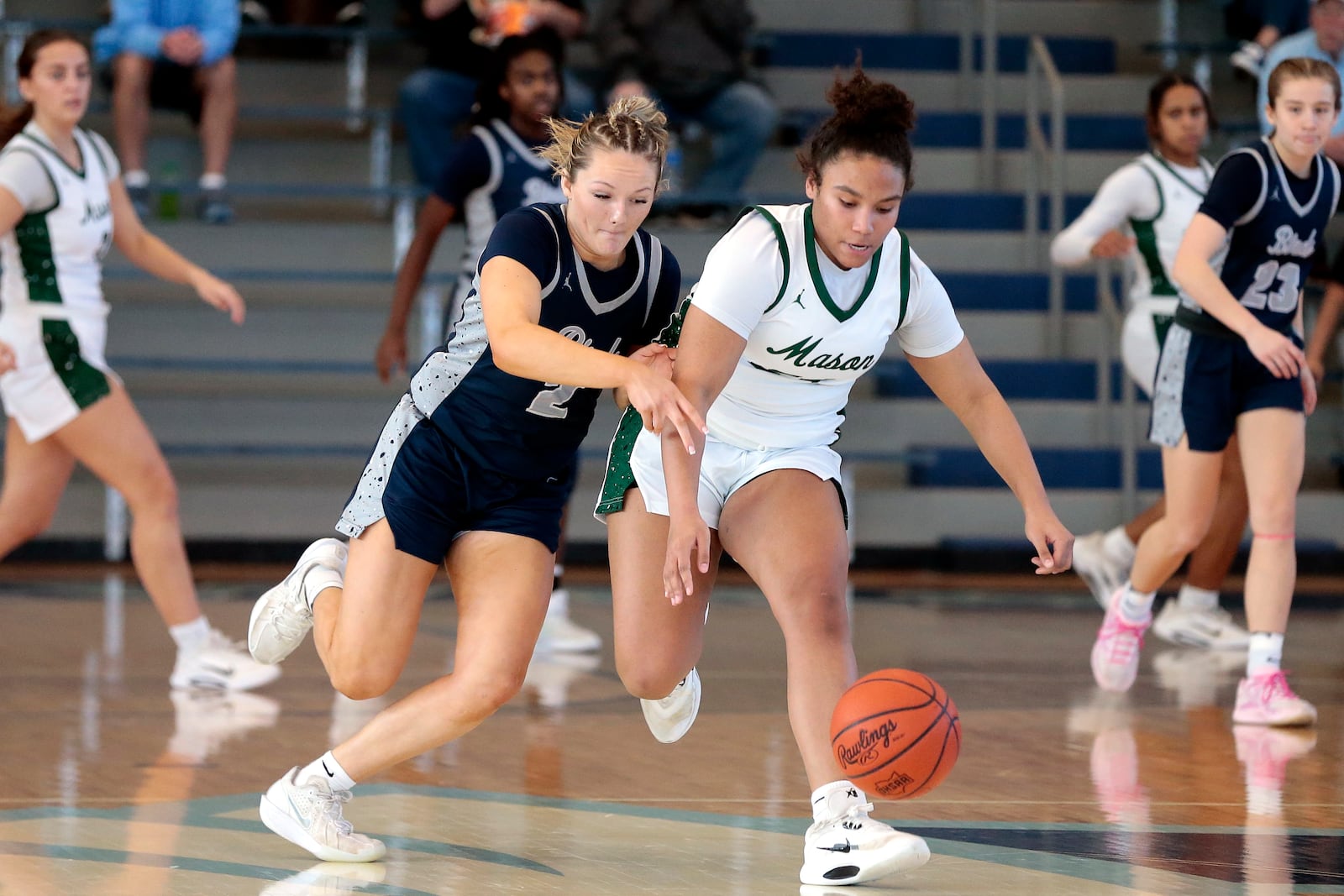 Fairmont senior Nico Cornett and Mason sophomore Nicole Davis chase down a loose ball. Fairmont defeated Mason 61-31 in a Division I district championship game on Saturday, Feb. 28, 2026, in Fairborn. STEVEN WRIGHT / STAFF