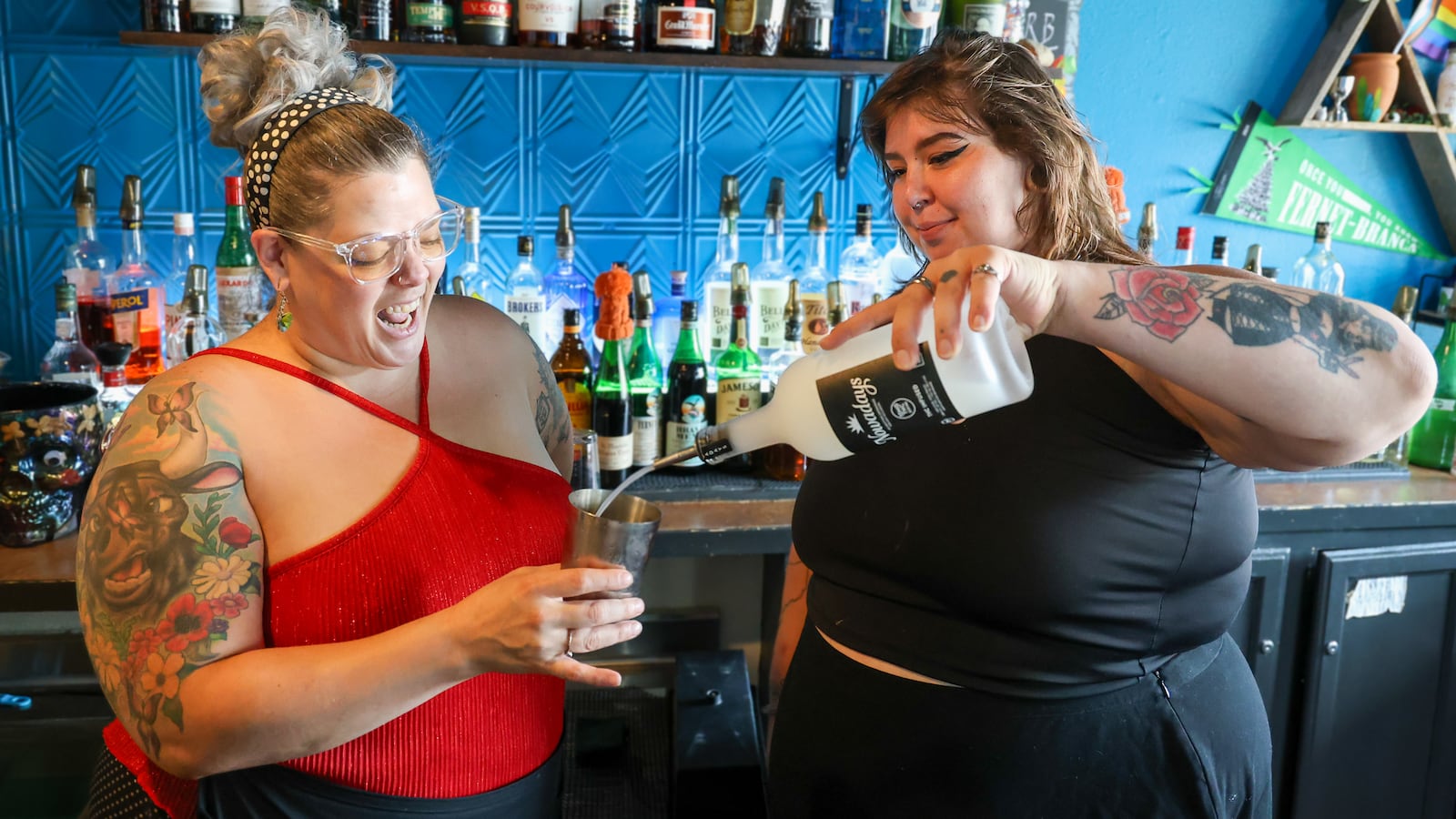 Meghan Ashley, a bartender at Lily's in the Oregon District, pours a shot of THC drink in a container held by Sara Roseberry, an assistant general manager, during lunchtime on Wednesday, Aug. 13. BRYANT BILLING / STAFF