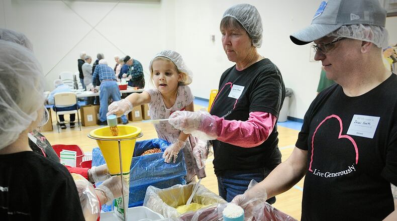 Over 140 volunteers from ages of 3 to 85 years old, packed over 35,640 meals Saturday, Jan. 20, 2024 for third world countries at the Abiding Christ Church in Fairborn. From left, Jennifer Dysert, Linda Kruse and Jason Health. MARSHALL GORBY\STAFF