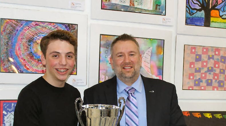 Kettering Middle School Principal Brian Snyder shows off a 2018 attendance trophy with one of his students. The trophy went back to rival Van Buren Middle School last week. CONTRIBUTED