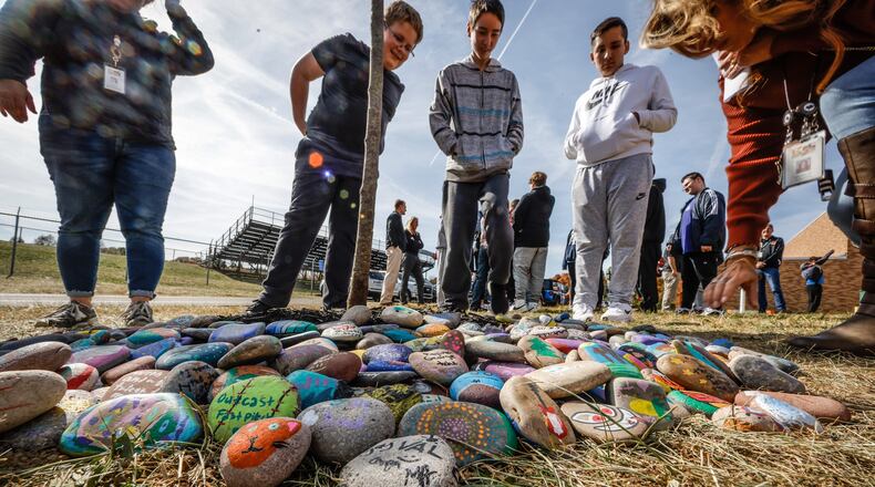 Eighth graders at Ankeney Middle School place "Positivity Rocks" at the school in Beavercreek Friday afternoon October 21, 2022. The students were ask to share their joy by writing positive comments on stones and placed around a tree. The school hopes the students feel connected to their school and community. JIM NOELKER/STAFF