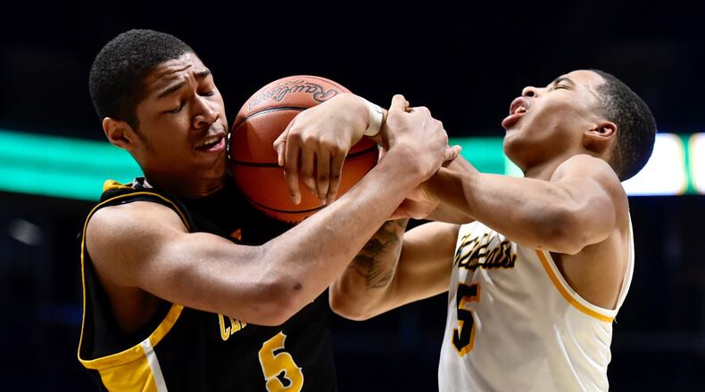 Mo Njie of Centerville (left) battles Ra’Heim Moss of Springfield for a rebound. NICK GRAHAM / STAFF