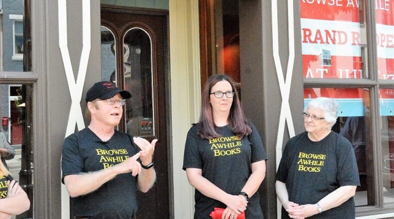 Bill Jones, left, owner of Browse Awhile Books in Tipp City, talks to supporters during ribbon cutting for bookstore rebuilt following a June 2016 fire. The store is scheduled to reopen Saturday. Shown with Jones are employees Amanda Carl and Thelma Moore.