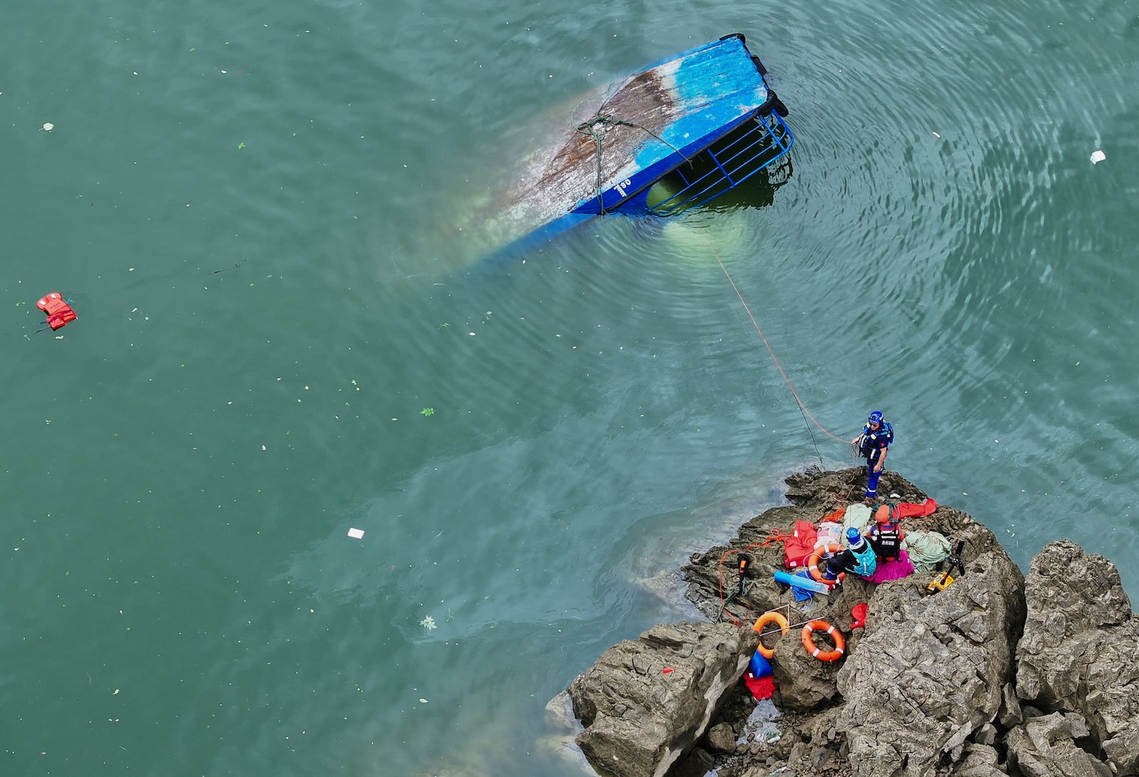 In this photo released by Xinhua News Agency, rescuers conduct a search and rescue operation at one of the two passenger boats capsized in Qianxi City, southwest China's Guizhou Province on Monday, May 5, 2025. (Liu Xu/Xinhua via AP)