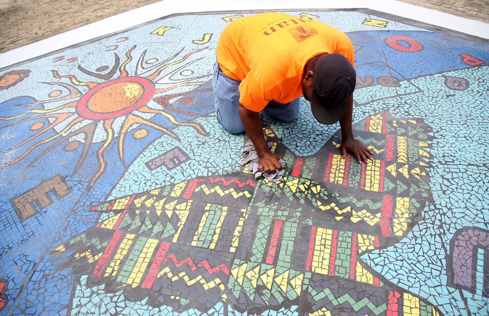 "Together We Rise," is a new large-scale play area and work of art in West Dayton. The in-ground mosaic is a play station designed with interactive games, alphabet letters and raised areas for crayon rubbings. It is located in a playground at the intersection of Harvard Boulevard and Burroughs Drive on the Omega CDC Harvard Campus.  LISA POWELL / STAFF