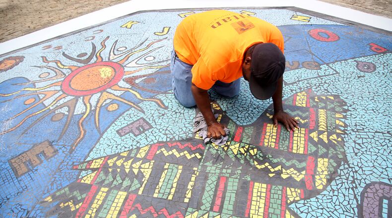 "Together We Rise," is a new large-scale play area and work of art in West Dayton. The in-ground mosaic is a play station designed with interactive games, alphabet letters and raised areas for crayon rubbings. It is located in a playground at the intersection of Harvard Boulevard and Burroughs Drive on the Omega CDC Harvard Campus. LISA POWELL / STAFF
