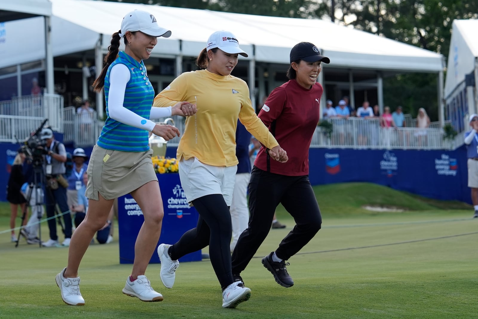 Mao Saigo, of Japan, in yellow, prepares to dive into the water off the 18th green after winning the Chevron Championship LPGA golf tournament Sunday, April 27, 2025, in The Woodlands, Texas. (AP Photo/Ashley Landis)