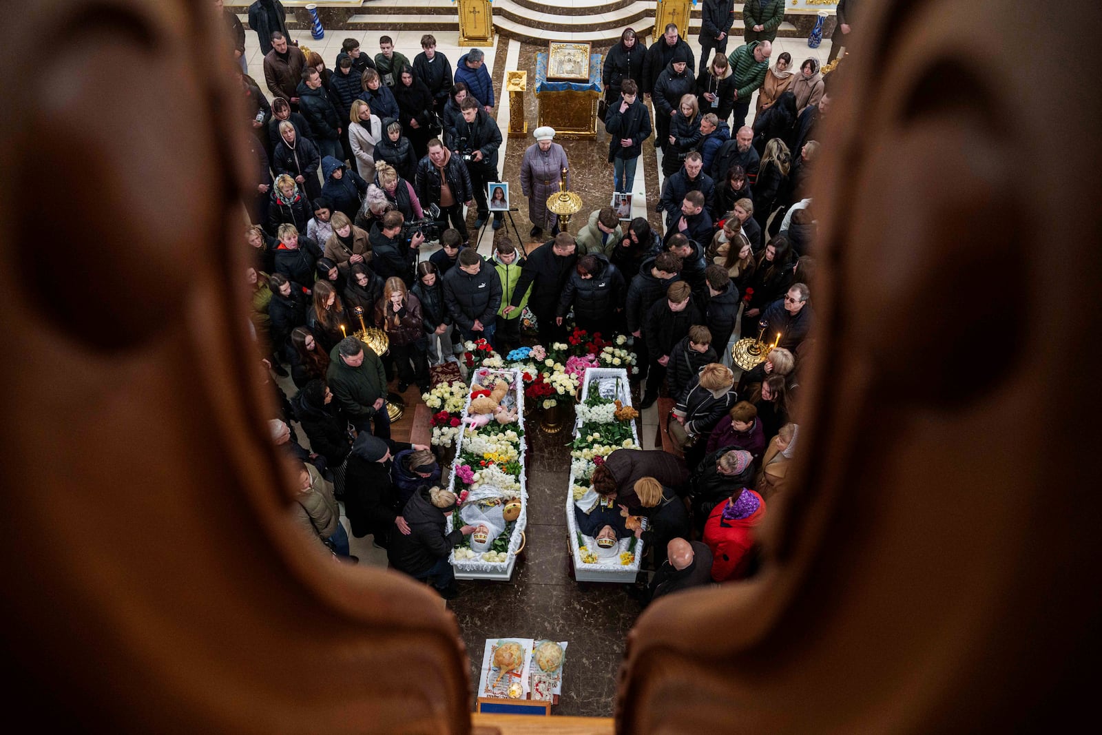 Mothers cry at the coffins of their children Danylo Nikittskyi, 15, right, and Alina Kutsenko, 15, left, killed by a Russian missile, during a funeral ceremony in Kryvyi Rih, Ukraine, April 7, 2025. (AP Photo/Evgeniy Maloletka)