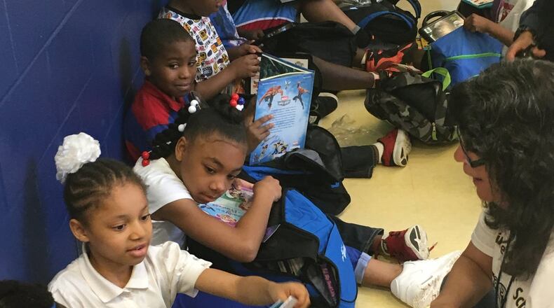 Third-graders at Fairview School in Dayton check out new books in May 2016, courtesy of the Read On program. JEREMY P. KELLEY/STAFF