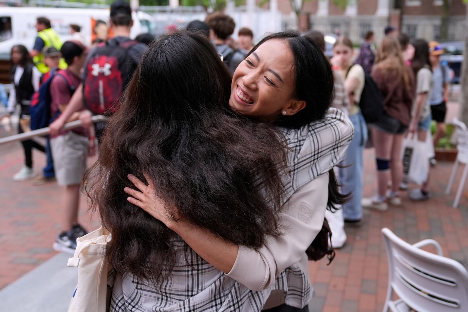 Yurong "Luanna" Jiang, who delivered a speech at her Harvard University commencement, smiles while embracing her friend Helen Ji, Friday, May 30, 2025, in Cambridge, Mass. (AP Photo/Charles Krupa)