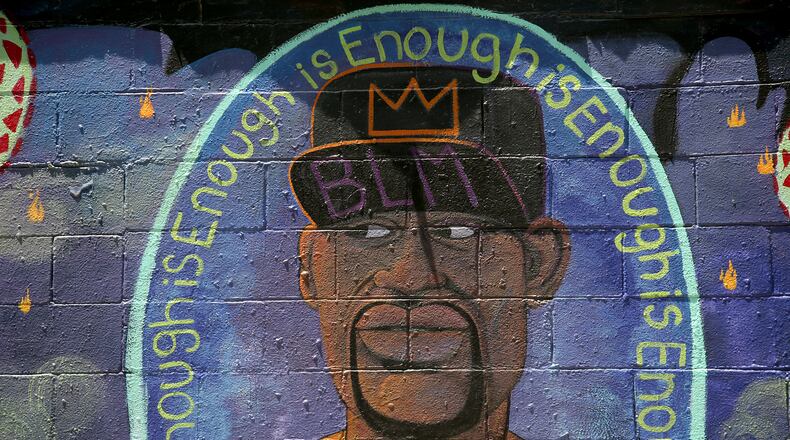 Two new murals in Yellow Springs pay tribute to George Floyd and the global protest movement held in response to his death. Artists Pierre Nagley and Lindsay Burke have created the murals in Kieth’s Alley, an area stretching behind the businesses along Xenia Ave. where artists have painted murals since the late 1980s. LISA POWELL / STAFF