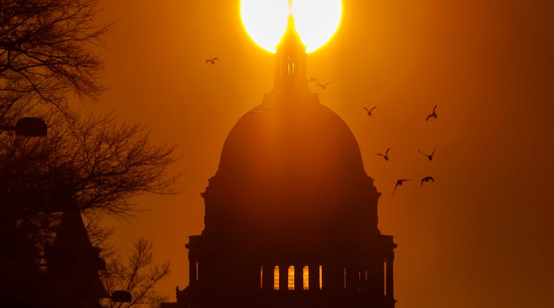 FILE - Birds fly near the U.S. Capitol during sunrise, Feb. 13, 2026, in Washington. (AP Photo/Tom Brenner, File)