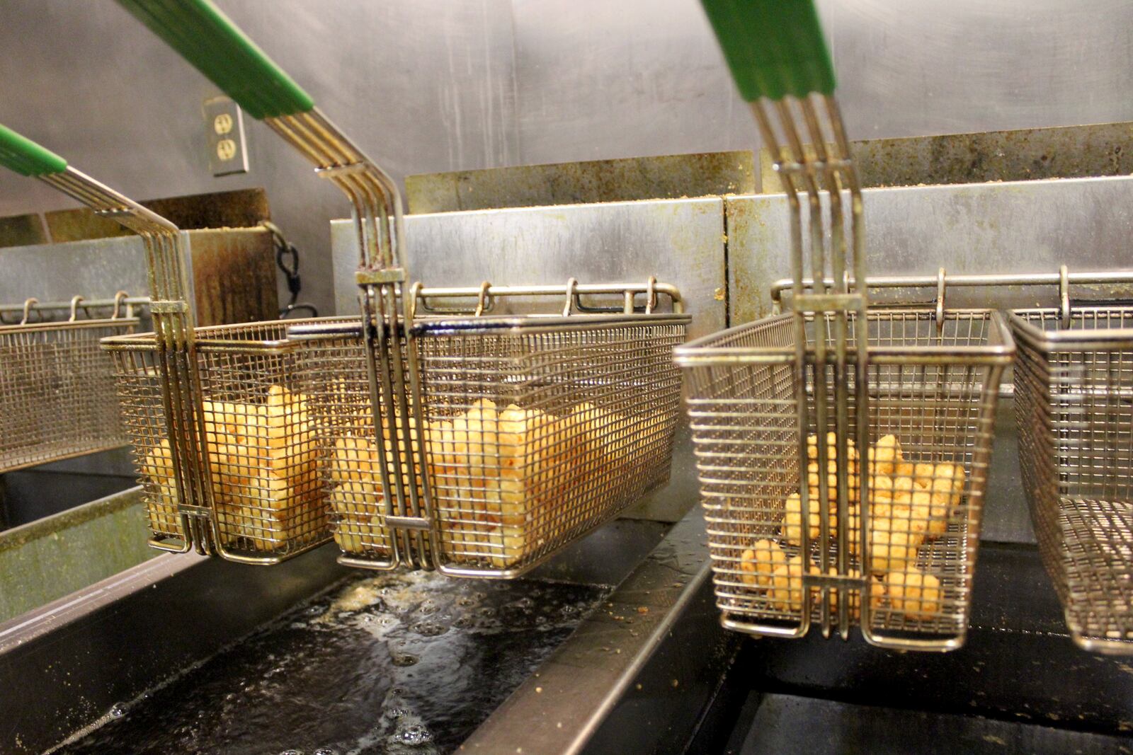 Large bucket of tater tots is made with two fryer baskets full of tots at Kings Table in Beavercreek. A side of tots is in the basket to the right for comparison.