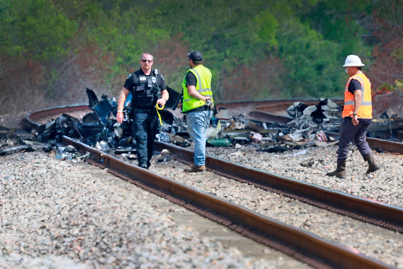 Emergency personnel respond to the area where a small plane crashed on the railroad tracks beneath the overpass near Interstate 95 in Boca Raton, Fla., on Friday, April 11, 2025. (Mike Stocker /South Florida Sun-Sentinel via AP)