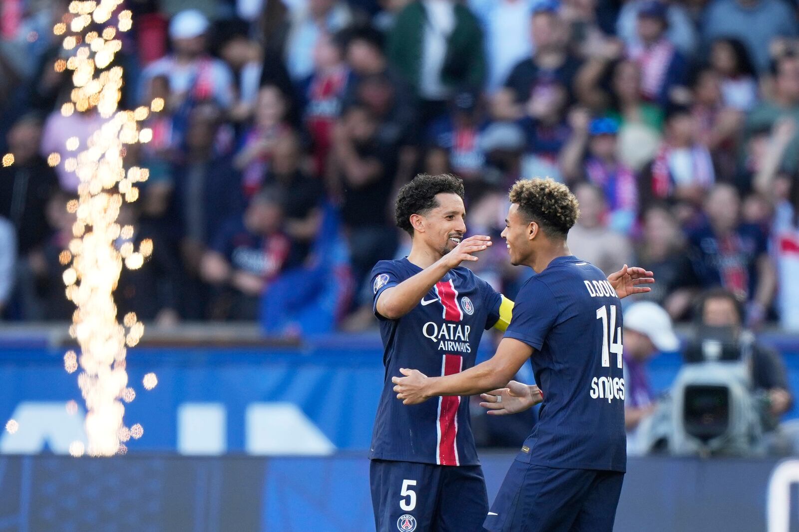PSG's Marquinhos, left, and PSG's Desire Doue celebrate their victory at the French League One soccer match between Paris Saint-Germain and Angers at Parc des Princes stadium in Paris, Saturday, April 5, 2025. (AP Photo/Michel Euler)