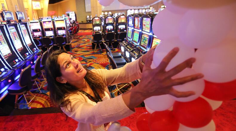 Dee Mara, marketing director at Hollywood Gaming at Dayton Raceway, sets up a column of balloons in the gaming area in preparation of the racino’s 1-year anniversary celebration event in 2015. JIM WITMER/STAFF