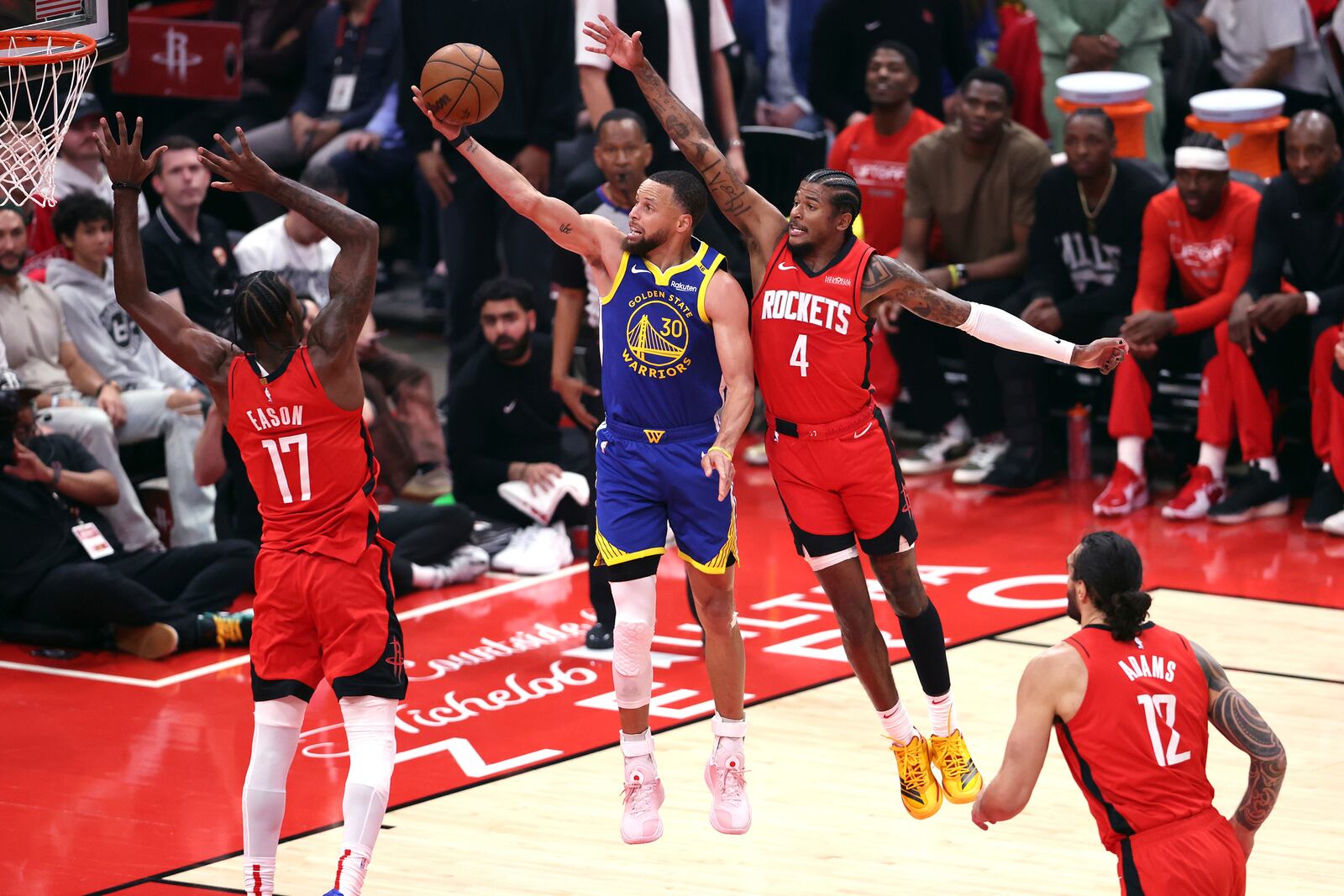 Golden State Warriors' Stephen Curry (30) scores against Houston Rockets' Tari Eason (17) and Jalen Green (4) during the first half of Game 1 of an NBA basketball first-round playoff series in Houston, Sunday, April 20, 2025. (Scott Strazzante/San Francisco Chronicle via AP)