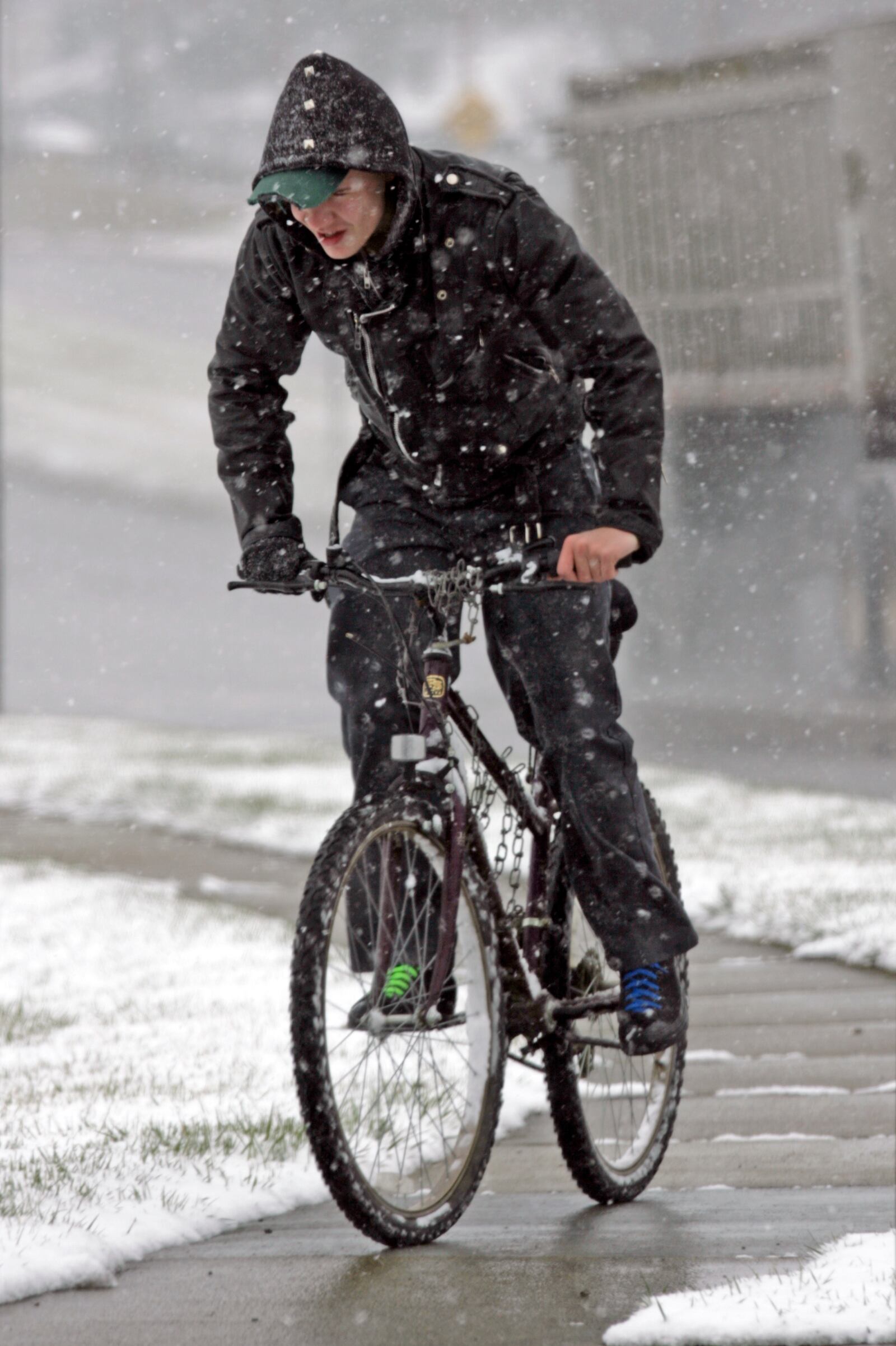 Chris Burton braves the snow Tuesday, March 21, 2006 as he rides his bike near the intersection of Highland Street and Roosevelt Ave in Middletown, Ohio. STAFF FILE PHOTO BY GARY STELZER
