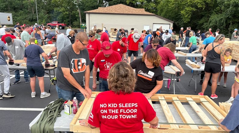 Volunteers nail bed frames together at Fairhaven Church's "Family Serve Day" Saturday Aug. 23, 2025. More than 800 volunteers assembled beds and packaged meals at the church. THOMAS GNAU/STAFF