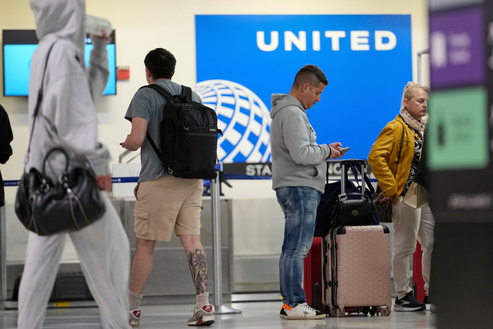 People prepare to board flights at Newark Liberty International Airport in Newark, N.J., Monday, May 5, 2025. (AP Photo/Seth Wenig)