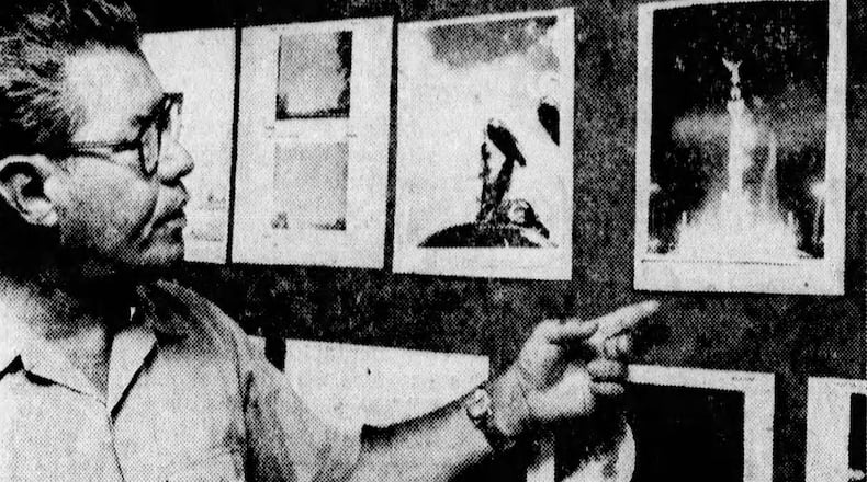 Lt. Col. Hector Quintanella looks at photos of so-called UFOs displayed in the Project Blue Book office at Wright-Patterson Air Force Base in 1968. DAYTON DAILY NEWS ARCHIVES