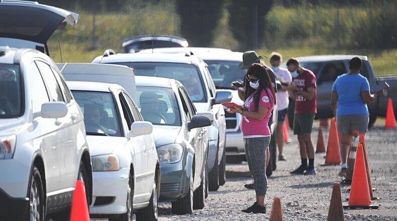 Vehicles line up for a mass food distribution at Wright State University's Nutter Center on Thursday, Sept. 10, 2020. STAFF PHOTO / MARSHALL GORBY