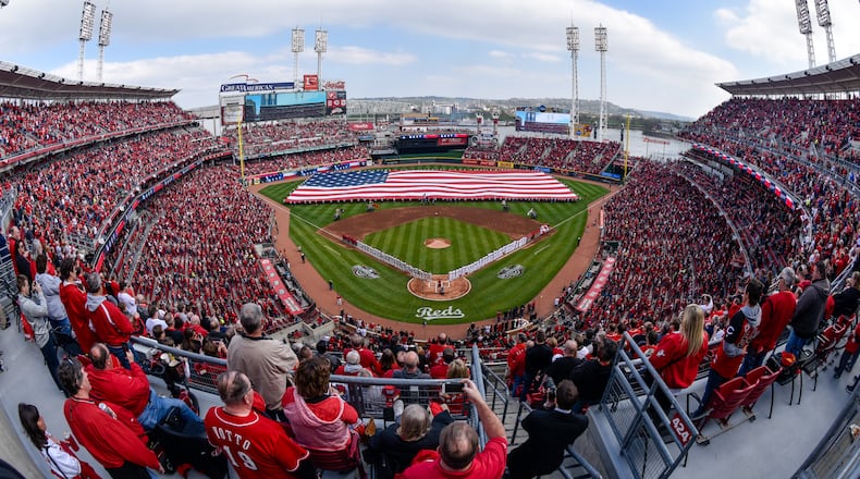 Thousands of fans stand during the National Anthem prior to the start of the Reds Opening Day game against Philadelphia Monday, April 4 at Great American Ball Park in Cincinnati. NICK GRAHAM/STAFF