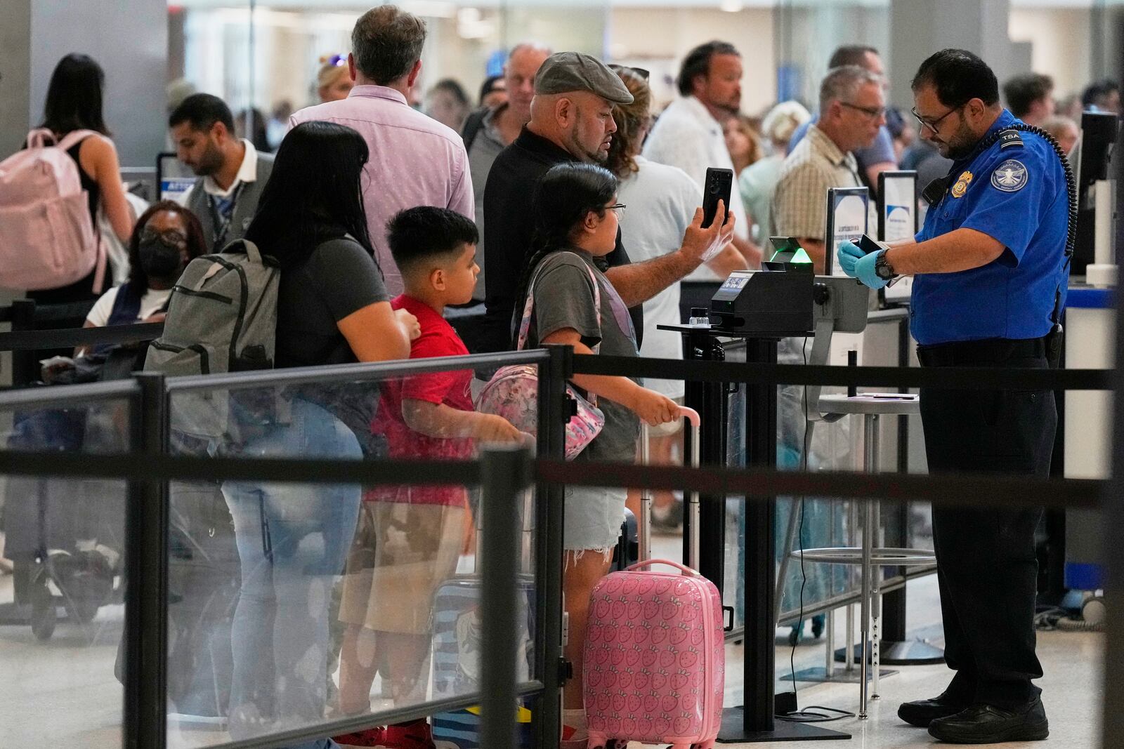Travelers makes their way through security at the Nashville International Airport, Thursday, July 17, 2025, in Nashville, Tenn. (AP Photo/George Walker IV)