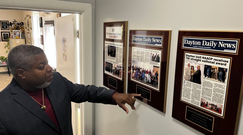 Dayton Unit NAACP President Derrick Foward shows framed news coverage from the Dayton Weekly News and Dayton Daily News, spotlighting awards the organization has won, in the NAACP's new headquarters building on Salem Avenue. JEREMY P. KELLEY / STAFF