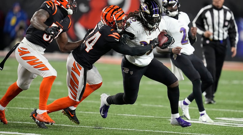 Baltimore Ravens running back Gus Edwards is stopped by Cincinnati Bengals safety Vonn Bell (24) in the first half of an NFL wild-card playoff football game in Cincinnati, Sunday, Jan. 15, 2023. (AP Photo/Darron Cummings)